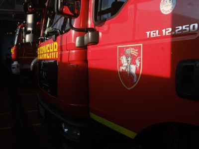 Nahaufnahme mehrerer roter Feuerwehrfahrzeuge mit gelber Schrift und Wappen auf der Fahrertür